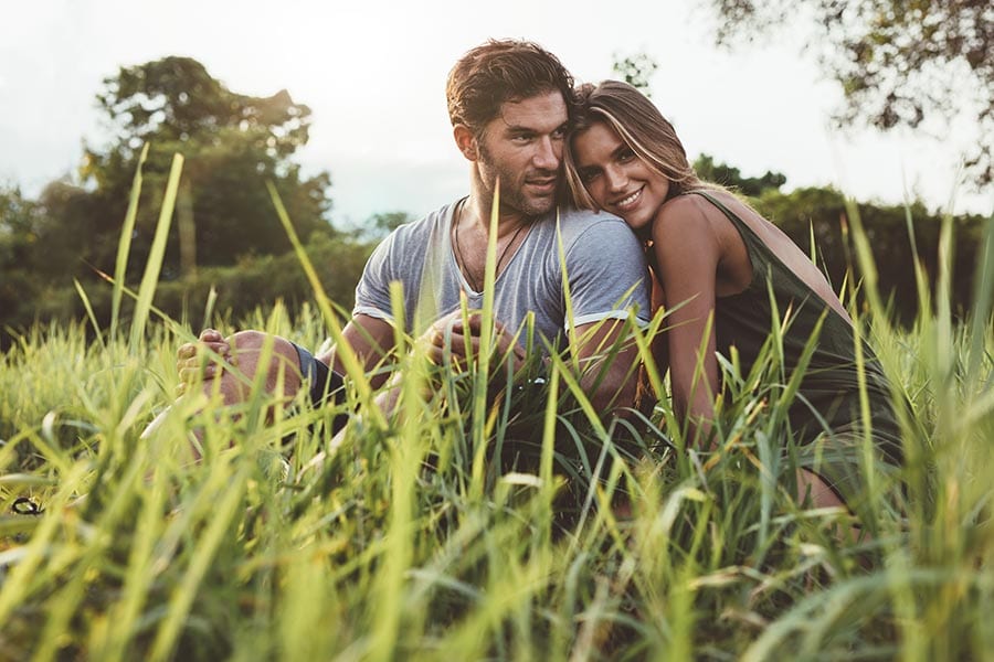 a couple cuddling in the grass