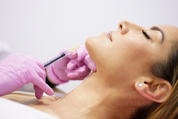 a woman getting botox injected into her chin
