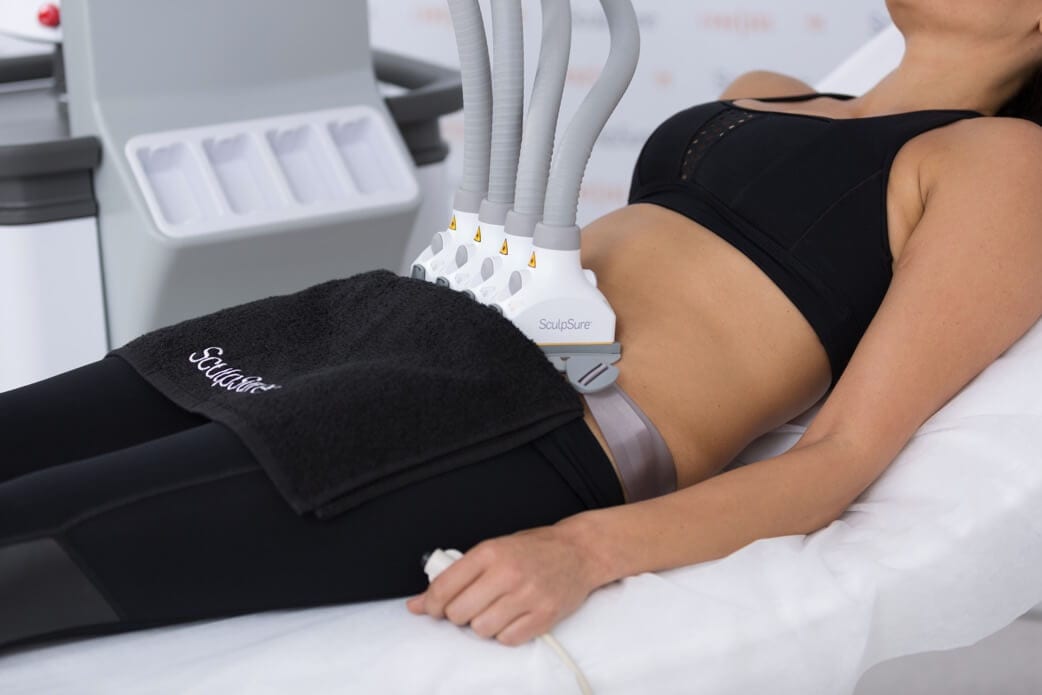 a machine with four hoses pressed to a woman's lower belly
