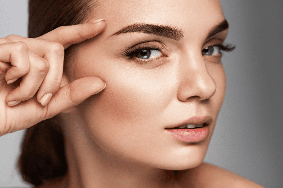 A woman is receiving wellness services at Limelight Medical Spa, as a professional applies laser treatment on her face.