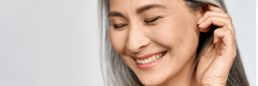 A woman with gray hair is smiling at the Limelight Medical Spa, a Health Spa offering Wellness Services.