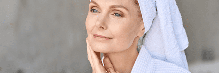 A woman receiving wellness services at a health spa in Cincinnati with a towel on her face.