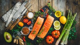 Health Spa offering a delectable assortment of salmon and vegetables on a cutting board.
