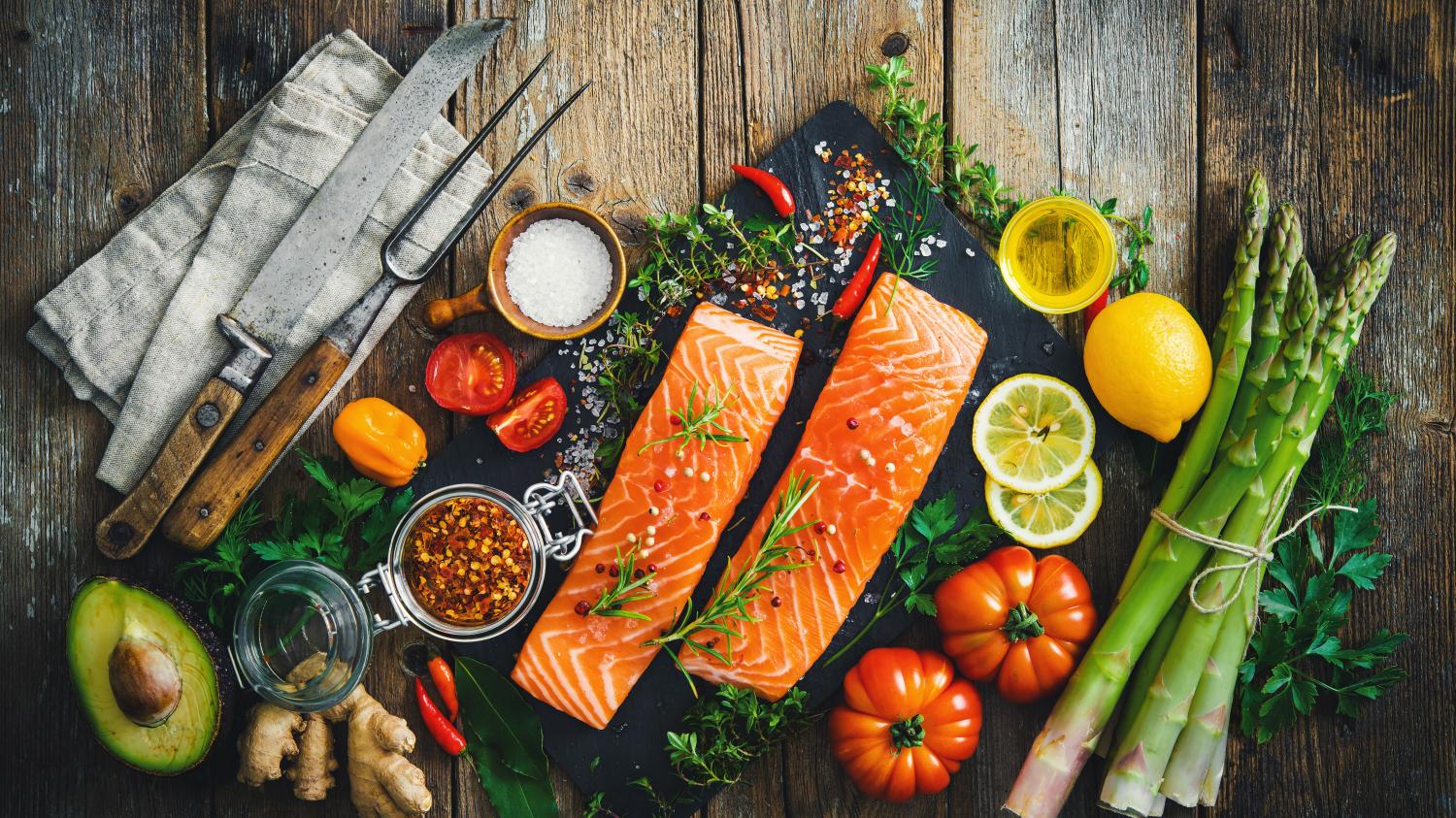 Health Spa offering a delectable assortment of salmon and vegetables on a cutting board.