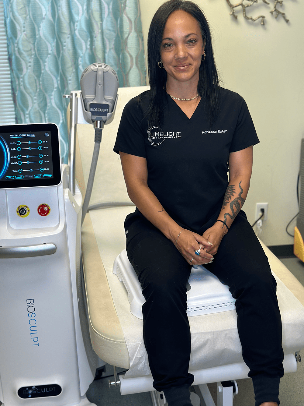 A woman sitting on a machine at Limelight Medical Spa in Cincinnati, receiving wellness services.