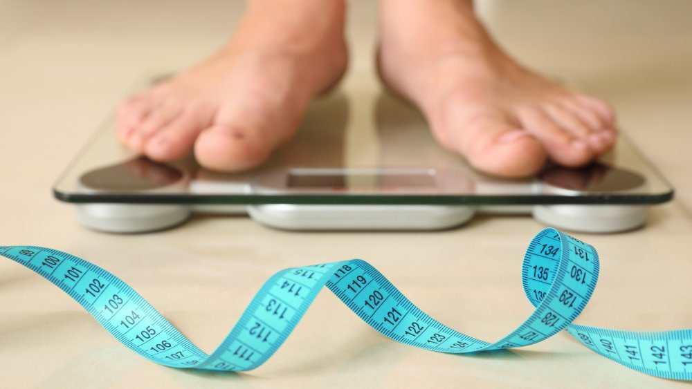 A person's feet on a scale at Limelight Medical Spa in Cincinnati, receiving wellness services.